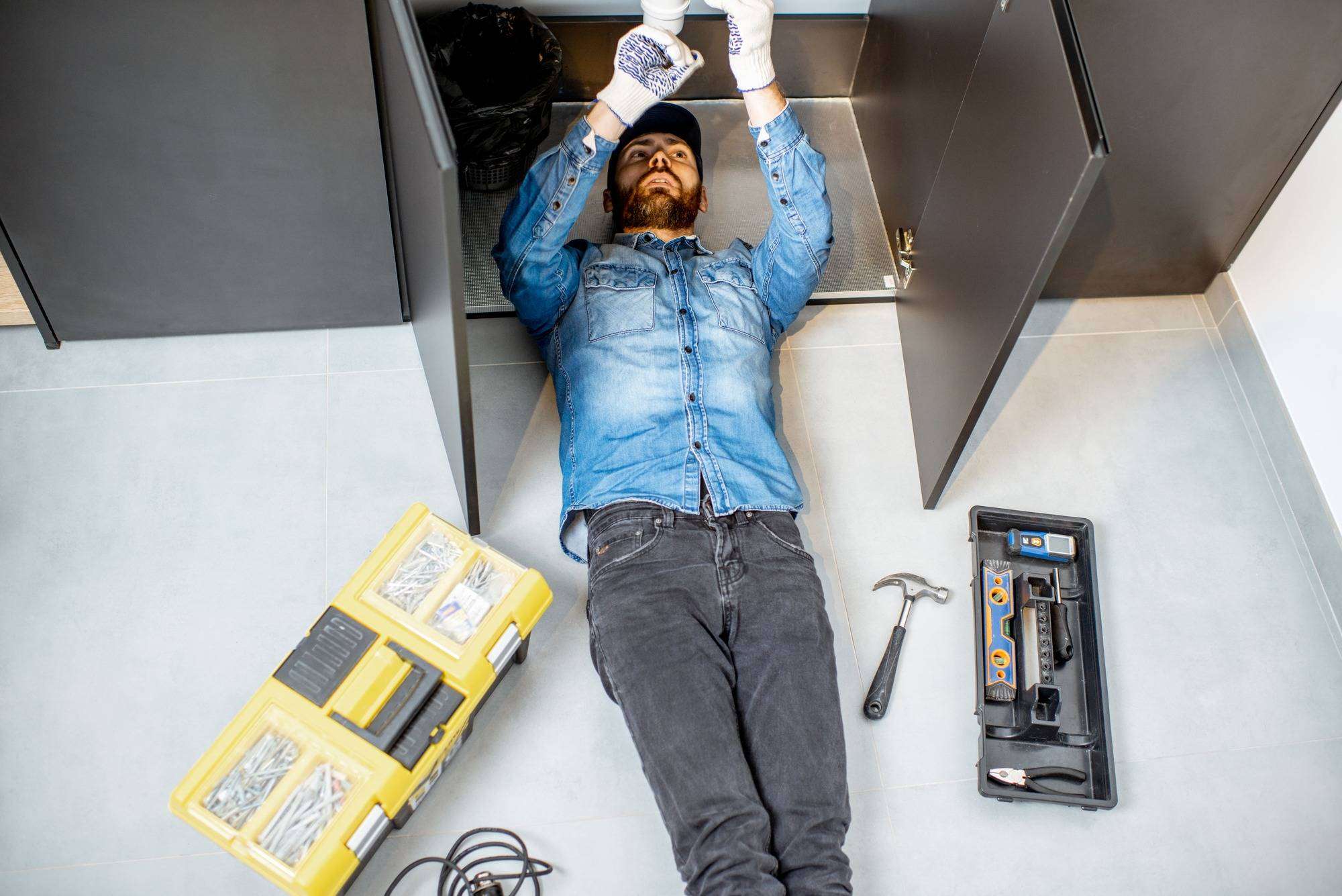 man-repairing-kitchen-plumbing-2022-01-19-00-17-35-utc